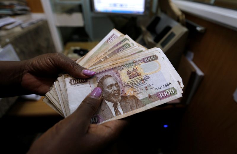 A teller counts Kenya shilling notes inside the cashier's booth at a forex exchange bureau in Kenya's capital Nairobi